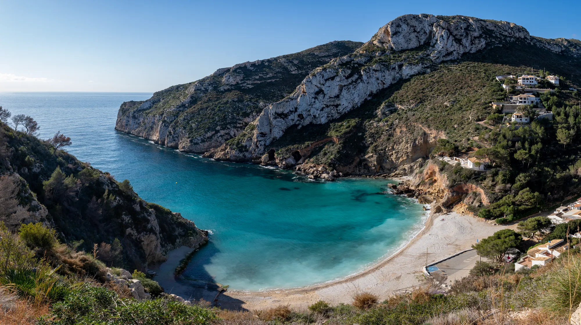 Baai met turquoise water onder de kliffen bij Jávea
