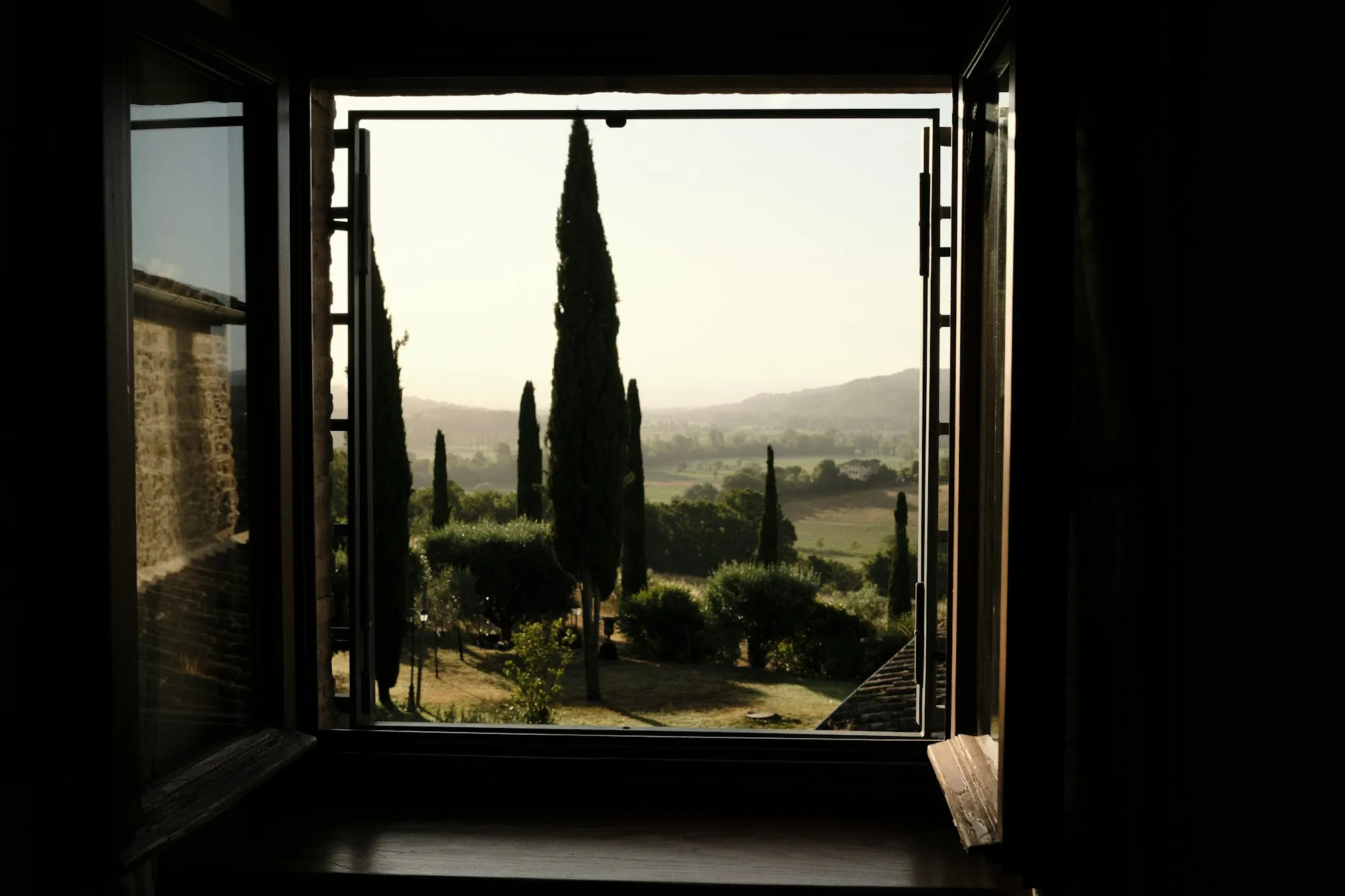 Uitzicht over het Toscaanse landschap door een open raam